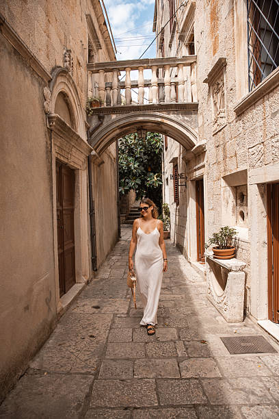 istock Stylish Female Tourist Exploring Old Town Architecture - 2220391014
