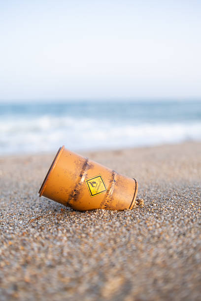 istock Rusty barrel with flammable sign polluting sandy beach 2220391088