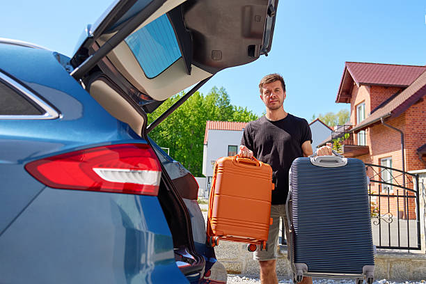 istock Man with suitcases near car, preparing for moving 2220391988