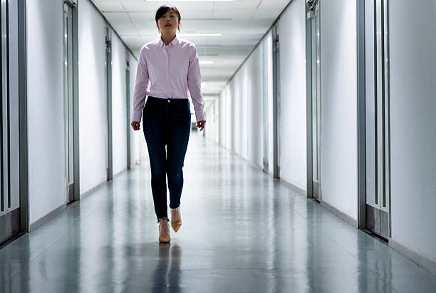 istock Front view of woman walking in a corridor 2220394142
