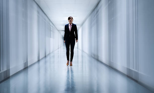 istock Front view of woman walking in a corridor 2220394158