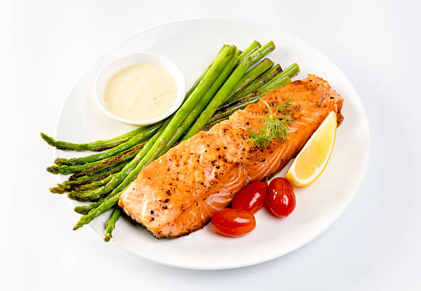 Grilled Salmon with Asparagus, Tomatoes and Lemon on White Plate