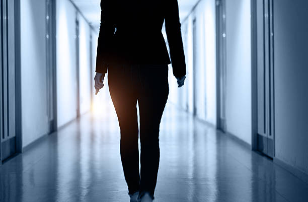 istock Woman walking and using mobile phone in a corridor 2220394218