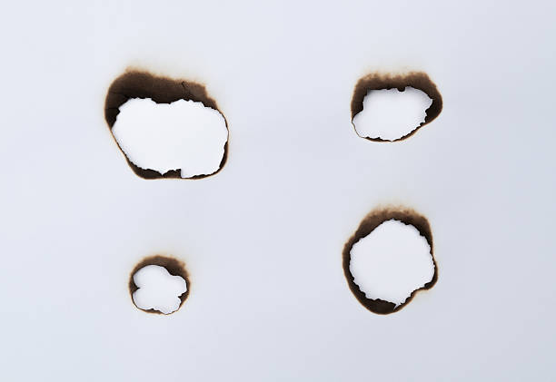 istock The white paper was burned with holes 2220394598