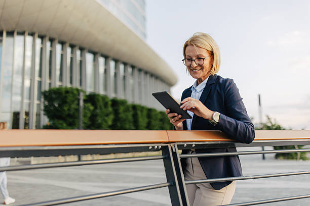 Optimistic woman enjoying tablet at urban place
