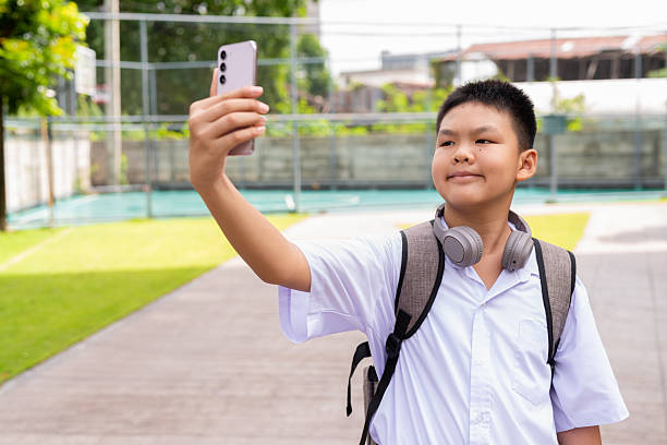 istock Schoolboy Relaxing in Park After Class 2220399262