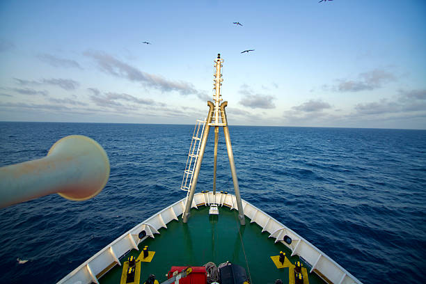 View of the bow of a cable ship at sea under dramatic sky, navigation lights are fitted on the forward mast.