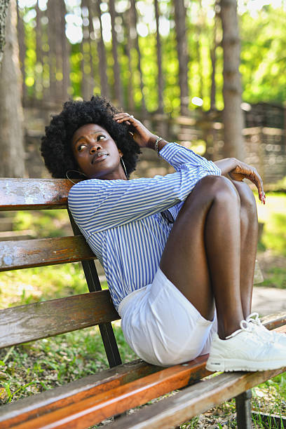 istock Lovely Female Enjoying the Outdoors While Sitting Peacefully on Bench in Forest Setting 2220399966