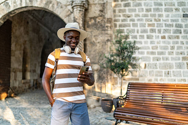 istock Smiling tourist using smartphone in front of ancient building 2220403166