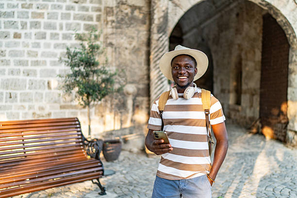 istock Smiling tourist using smartphone in front of ancient building 2220403250