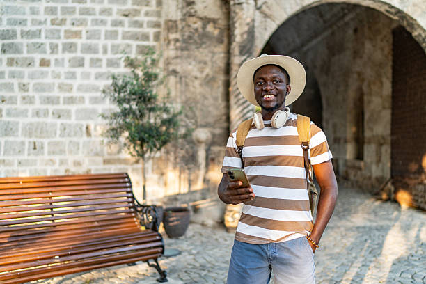 istock Young man exploring a historical site, holding his smartphone 2220403280