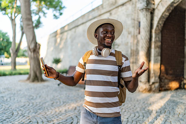 istock Young man enjoying a sunny day, using his phone and smiling 2220403379