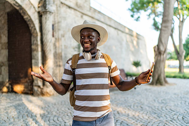 istock Tourist holding smartphone gesturing in front of ancient building 2220403437