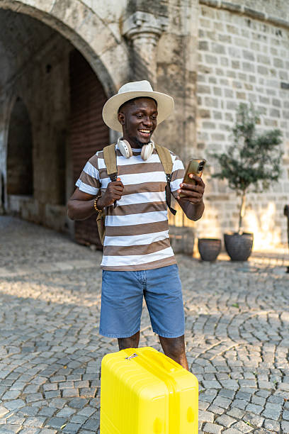 istock Young black tourist using a smartphone in a historical city center 2220403465