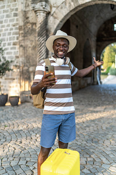 istock Young black tourist making a video call in front of an ancient building 2220403516