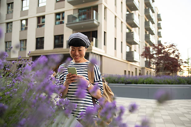 istock Smiling tourist using smartphone while exploring city lavender garden 2220403547