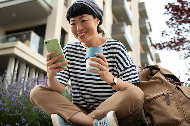 istock Smiling tourist enjoying coffee and browsing smartphone in urban setting 2220403639