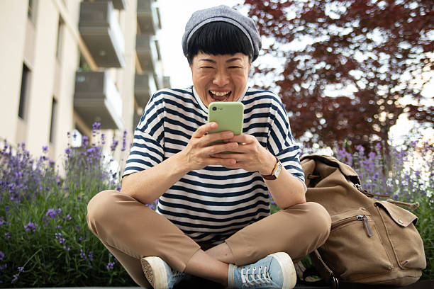 istock Happy tourist laughing while using mobile phone outdoors 2220403672