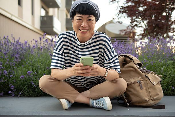 istock Smiling tourist using smartphone while relaxing outdoors 2220403700