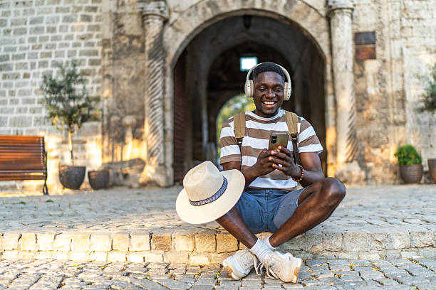 istock Tourist enjoying music and using smartphone app in front of ancient gate 2220403851