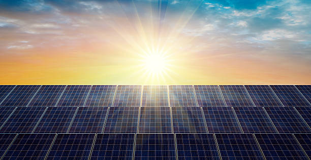 istock Solar panels at bright sunrise with light rays and blue sky 2220404660