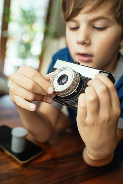 istock Child with retro camera at home 2220405499