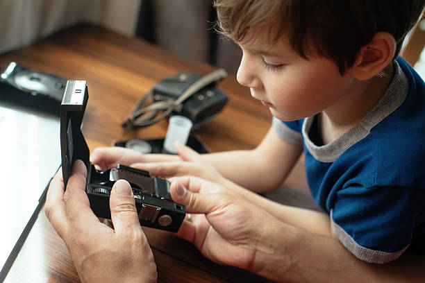istock Man showing old retro camera to his son 2220405552