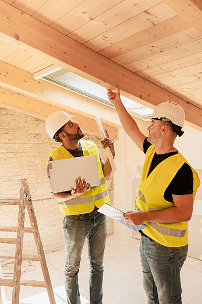 istock Two Construction workers or architect with laptop inspecting wooden beams at building site 2220407113