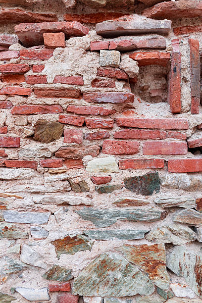 istock Closeup textured brick wall with ancient layered stone and red masonry. 2220407226