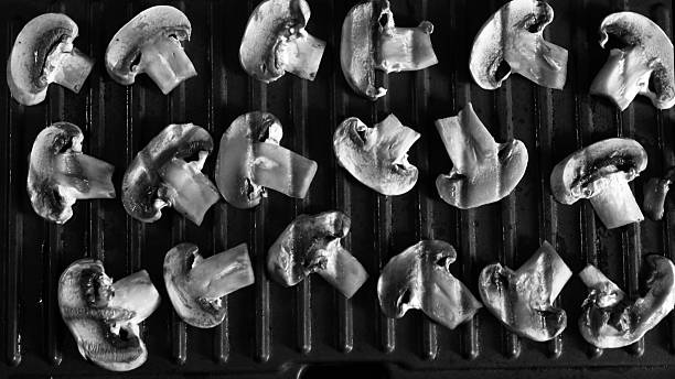 istock Sliced ​​champignon mushrooms on an electric grill. 2220410987