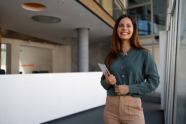 istock Smiling businesswoman using digital tablet, working confidently in contemporary corporate environment 2220416824