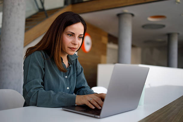 istock Concentrated professional typing on laptop, working intently at modern workspace with natural lighting 2220418176