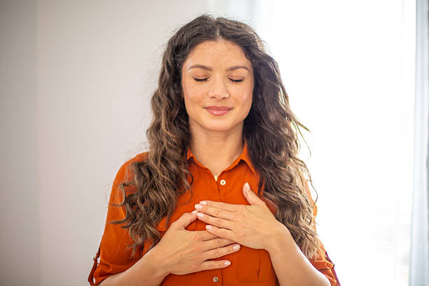 istock Serene woman expressing gratitude and hope with hands on chest 2220419235