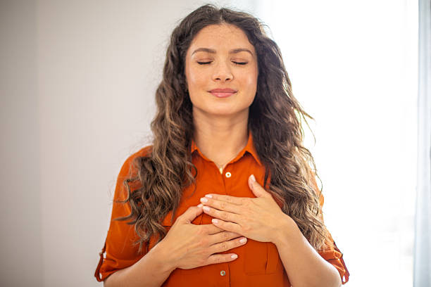 istock Serene young woman practicing gratitude and mindfulness with hands on chest 2220419328