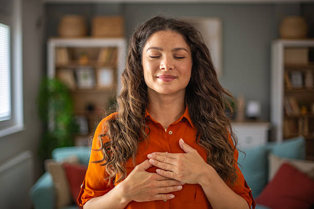 Serene woman practicing mindfulness at home with eyes closed