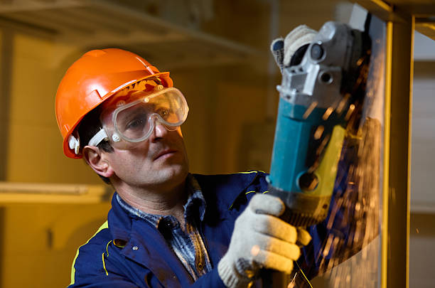 istock Male Builder grinding welds on metallic construction, focus on the working tool, close-up 2220420103