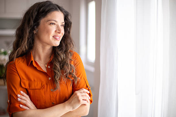 istock Young woman looking out the window, contemplating the future 2220420165