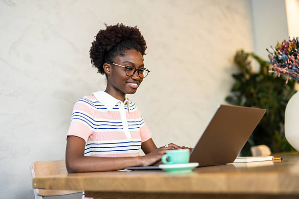 istock Young black female freelancer working on laptop in a coworking space 2220420377