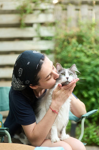 istock Woman gently kissing her fluffy cat in a backyard 2220420416