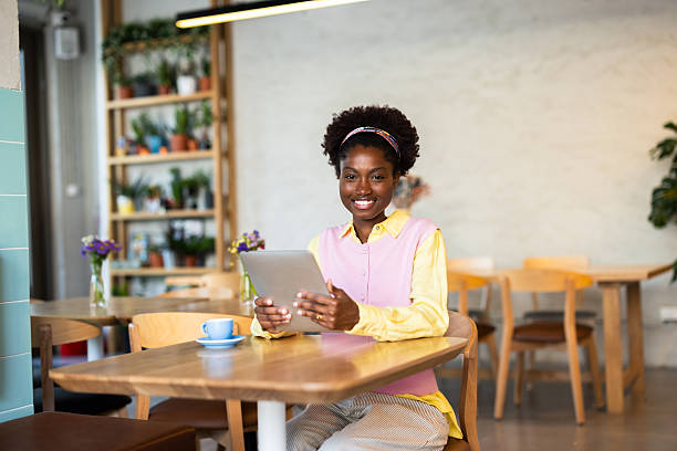 istock Young woman using digital tablet in cozy coffee shop 2220420994