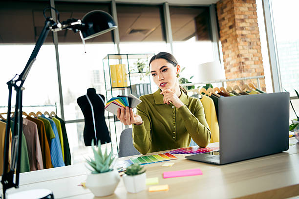 istock Young businesswoman in atelier workspace analyzing textile samples for creative fashion design projects 2220423265