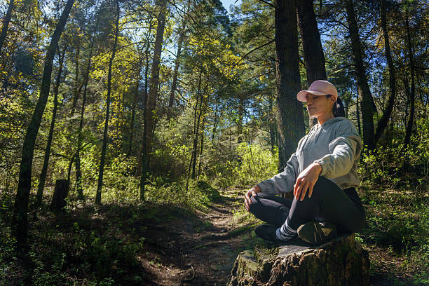 istock Young woman meditating in the forest during hike 2220425120