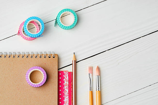 istock Crafting inspiration with colored pencils, decorative tape, and playful shapes on a rustic wooden surface 2220426436
