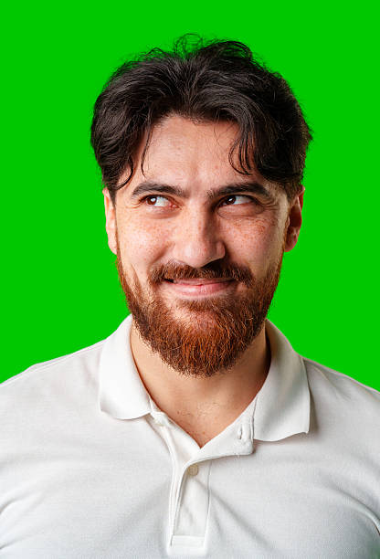 istock A young man with a beard showing a serious expression against a vibrant green background 2220427680