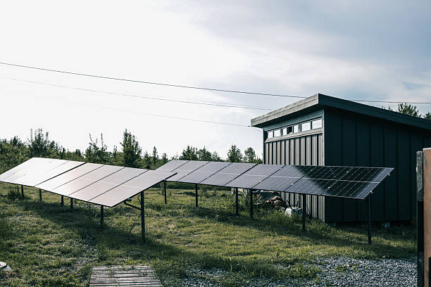 istock Solar panel installations beside a modern utility building in a green field, generating renewable energy on a sunny day 2220428091