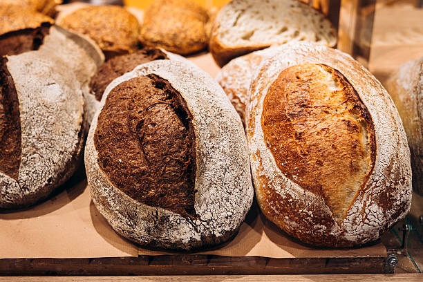 istock Freshly baked bread loaves displayed in bakery window with golden crusts. 2220428826