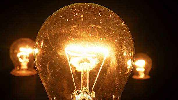 istock Glowing incandescent light bulbs in a dark environment 2220428838