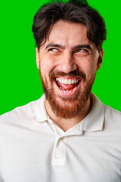 istock A man with a beard smiles confidently against a bright green background 2220428886