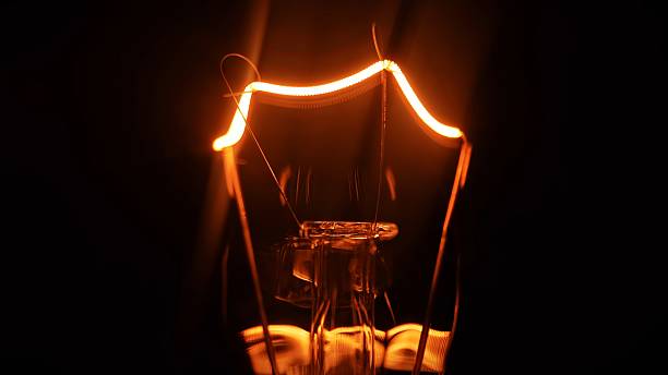 Glowing tungsten filament inside a vintage incandescent bulb