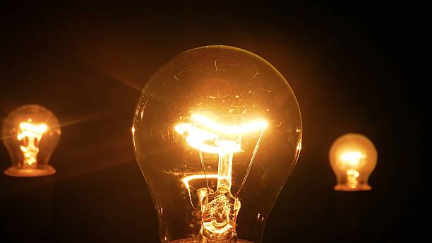 istock Glowing incandescent light bulbs in a dark environment 2220429748